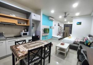 a kitchen and living room with a table in a room at Cozy Stay at Shaftsburry, Urban Convenience #SH1 in Cyberjaya