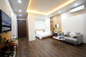 een woonkamer met een bed en een bank bij Fusion Gates Apartment in Hanoi