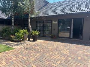 a brick driveway with plants in front of a building at 47 on Manson in Boksburg