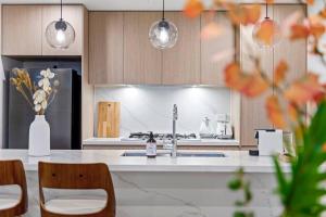シドニーにあるLuxury Penthouse 3 Bedrooms in Neutral Bayのキッチン(シンク、カウンター、椅子付) +11枚の写真