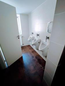 łazienka z 3 pisuarami i 3 toaletami w obiekcie Room in Guest room - Single room with shared bathroom and kitchen in Hundsbach w mieście Forbach