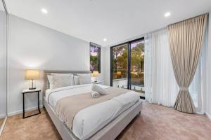 シドニーにあるLuxury Penthouse 3 Bedrooms in Neutral Bayの大きなベッドと大きな窓のある寝室