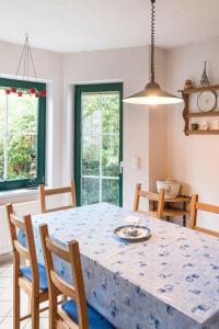 einen Esstisch und Stühle mit einem blauen Tischtuch in der Unterkunft Ferienhaus mit Gästezimmer für sechs Erwachsene und einem Kind bis sechs Jahre mit Terrasse und Garten in Zehdenick