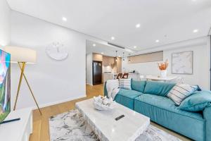 シドニーにあるLuxury Penthouse 3 Bedrooms in Neutral Bayの青いソファとテーブルのあるリビングルーム