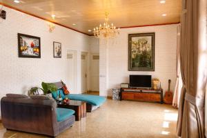 a living room with a couch and a tv at Scent Villa - Village in Da Lat