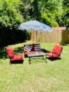 zwei Stühle und ein Regenschirm auf einem Hof in der Unterkunft Sug's Place in Dothan