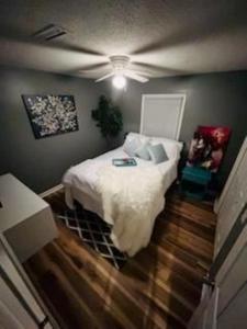 Schlafzimmer mit einem Bett mit weißer Bettwäsche und einer Decke in der Unterkunft Sug's Place in Dothan