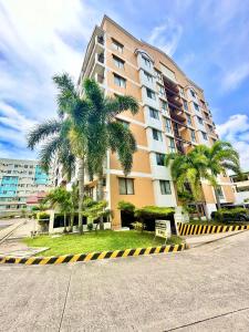 a large building with palm trees in front of it at Magallanes Residences Condominium 211&212B in Davao City