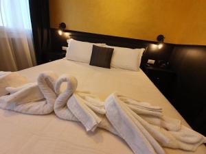 Una cama con dos toallas de cisne. en Ferienwohnung für 2 Personen ca 33 qm in Chioggia, Adriaküste Italien Venedig und Umgebung, en Chioggia