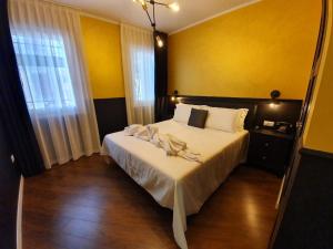 1 dormitorio con 1 cama con sábanas blancas y paredes amarillas en Ferienwohnung für 2 Personen ca 33 qm in Chioggia, Adriaküste Italien Venedig und Umgebung, en Chioggia