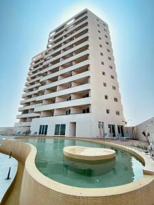 a large building with a pool in front of a building at Depto con alberca y Netflix condominio in Conchal