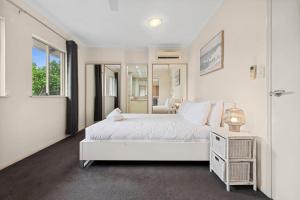 Un dormitorio blanco con una cama blanca y una ventana en Discover a Lush Poolside Stay at The Lakes Resort, en Cairns North