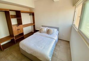 1 dormitorio con 1 cama con 2 almohadas y ventana en Depto con alberca, Netflix y Gym, se puede pescar, en Conchal