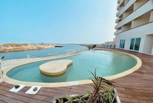 a large swimming pool on a deck next to a building at Depto con alberca y Netflix condominio in Conchal