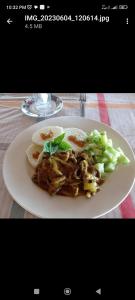 un plato de comida con verduras en una mesa en White Beach Bungalow & Restaurant en Lénakel