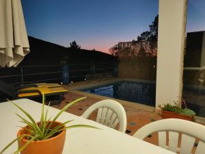 a patio with a table and chairs and a pool at Casa do Diospiro für 4 Personen Privatzimmer in São Bartolomeu de Messines