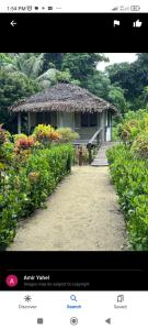 a page of a website with a house with flowers at White Beach Bungalow & Restaurant in Lénakel