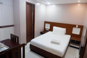 um pequeno quarto com uma cama e uma mesa em coastal hotel em Iloilo City