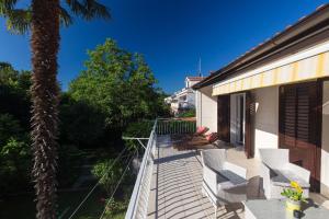 eine Terrasse mit weißen Stühlen und einer Palme in der Unterkunft Ferienwohnung für 3 Personen  1 Kind ca 60 m in Njivice, Kvarner Bucht Krk in Njivice
