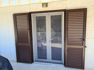 zwei Glasschiebetüren an der Seite eines Gebäudes in der Unterkunft Ferienwohnung für 3 Personen  1 Kind ca 60 m in Njivice, Kvarner Bucht Krk in Njivice