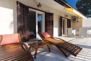 eine Holzbank auf der Rückseite einer Veranda in der Unterkunft Ferienwohnung für 3 Personen  1 Kind ca 60 m in Njivice, Kvarner Bucht Krk in Njivice