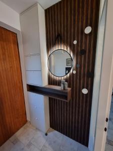 ein Badezimmer mit einem Spiegel und einer Holzwand in der Unterkunft Ferienwohnung für 3 Personen  1 Kind ca 60 m in Njivice, Kvarner Bucht Krk in Njivice + 13 Fotos