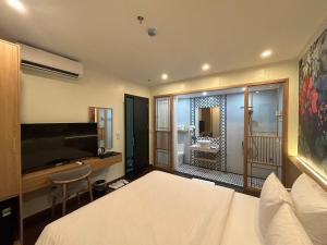 a bedroom with a bed and a bathroom with a sink at Grand Hotel HN- by BAY LUXURY in Hanoi