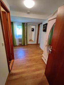 um corredor com cortinas verdes e piso de madeira em Room in Guest room - Pension Forelle - double room 001 em Forbach