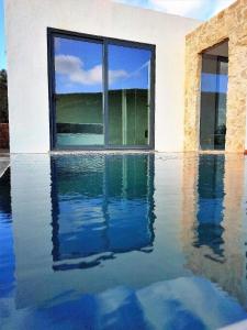 a house with a pool of water in front of a window at Casa da Cidreira - Villa für 4 Personen 2 private Suite in São Bartolomeu de Messines