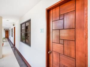 a wooden door in a room with a corridor at MCA Suites by Hiverooms in Cebu City +1 photo