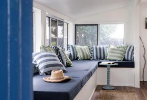 a hat sitting on a bench in a room with pillows at Seaspray Yeppoon in Yeppoon