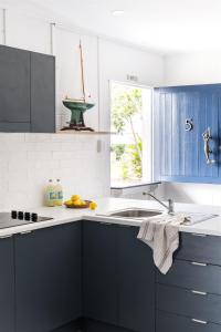 a kitchen with blue cabinets and a sink and a window at Seaspray Yeppoon in Yeppoon