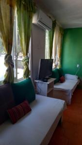 a room with two beds and a tv and a window at Paraíso Verde in Tambaca
