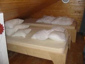 three beds with white pillows on them in a room at Ferienhaus für 4 Personen ca 42 qm in Hohenweiler, Vorarlberg Bodensee in Hohenweiler