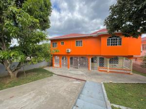 an orange house with a driveway in front of it at Boscobel Hillside Hideaway in St Mary