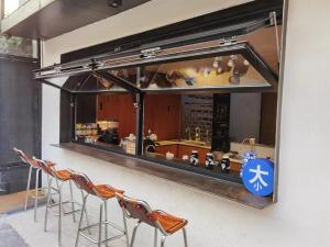 een bar met krukken voor een balie bij Refactoring Space Beijing Wang Fu Jing in Beijing