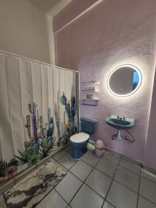 a bathroom with a blue toilet and a sink at Cozy 1 Bed Apartment in La Noria in Zihuatanejo