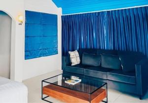 ein Wohnzimmer mit einem blauen Sofa und einem Couchtisch in der Unterkunft Samui Tonggad Resort in Koh Samui 