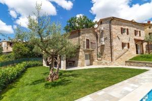 une vieille maison en pierre avec un arbre dans la cour dans l'établissement Villa Zoro mit schönen Garten und privatem Pool, à Pazin