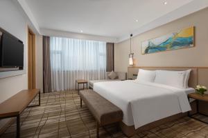 ein Hotelzimmer mit einem großen Bett und einem TV in der Unterkunft Holiday Inn Chengdu Airport, an IHG Hotel in Chengdu