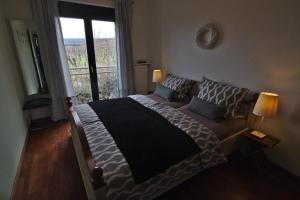 a bedroom with a large bed with a window at Appartement in Sasbach Am Kaiserstuhl mit Grill in Sasbach am Kaiserstuhl