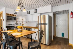 a kitchen with a wooden table and a stainless steel refrigerator at Big Fern Cabin in Vanderpool +17 photos