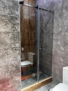 a shower with a glass door in a bathroom at Дом у озера in Chok-Tal