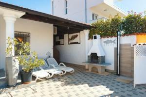 un patio con una parrilla y un banco y un edificio en Ferienhaus für 6 Personen ca 60 qm in Medulin, Istrien Südküste von Istrien en Medulin