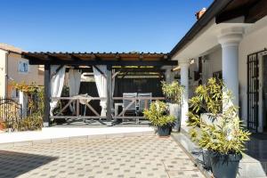 un pabellón con una mesa y macetas en un patio en Ferienhaus für 6 Personen ca 60 qm in Medulin, Istrien Südküste von Istrien en Medulin