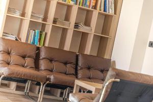 a brown leather couch in front of a book shelf at Chalet im Grünen in den Suedtiroler Dolomiten mit 17 Betten in Selva di Val Gardena