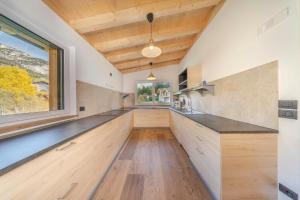 a kitchen with wooden counters and a large window at Chalet im Grünen in den Suedtiroler Dolomiten mit 17 Betten in Selva di Val Gardena