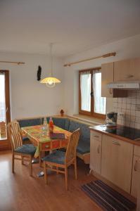 uma cozinha e sala de jantar com uma mesa e um sofá em Wohnung in Meransen em Maranza