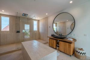 uma casa de banho com um lavatório e um espelho em Villa Namaskar - Iconic 5BR Cliff Top Villa - 180° Ocean View em Jimbaran