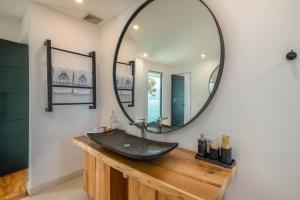 a bathroom with a large mirror and a sink at Villa Namaskar - Iconic 5BR Cliff Top Villa - 180° Ocean View in Jimbaran